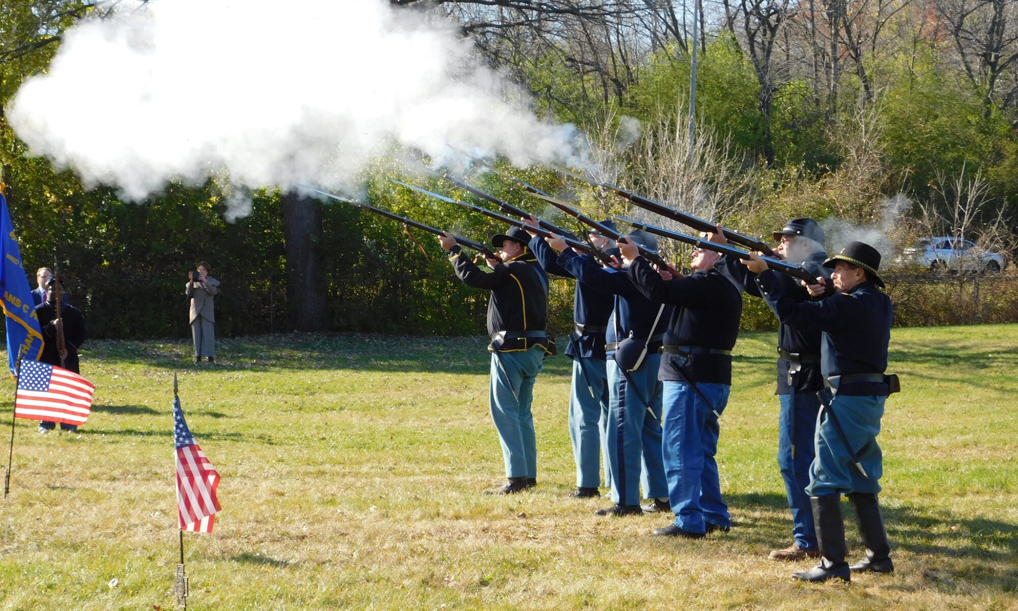 Men in Civil War uniforms fire rifles into the air.